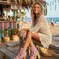 Model wearing Pink Aruba Boots by Sol Caleyo, featuring pink suede and high wooden platforms in a boho-chic aesthetic.