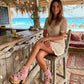 Model wearing Pink Aruba Boots by Sol Caleyo, featuring pink suede and high wooden platforms in a boho-chic aesthetic.