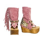 Handmade Atenea Pink Flip Flop Boots by Sol Caleyo, featuring pink suede leather, fringe details, shells, vintage coins, and a high wooden platform sole on a white background