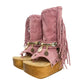 Handmade Atenea Pink Flip Flop Boots by Sol Caleyo, featuring pink suede leather, fringe details, shells, vintage coins, and a high wooden platform sole on a white background
