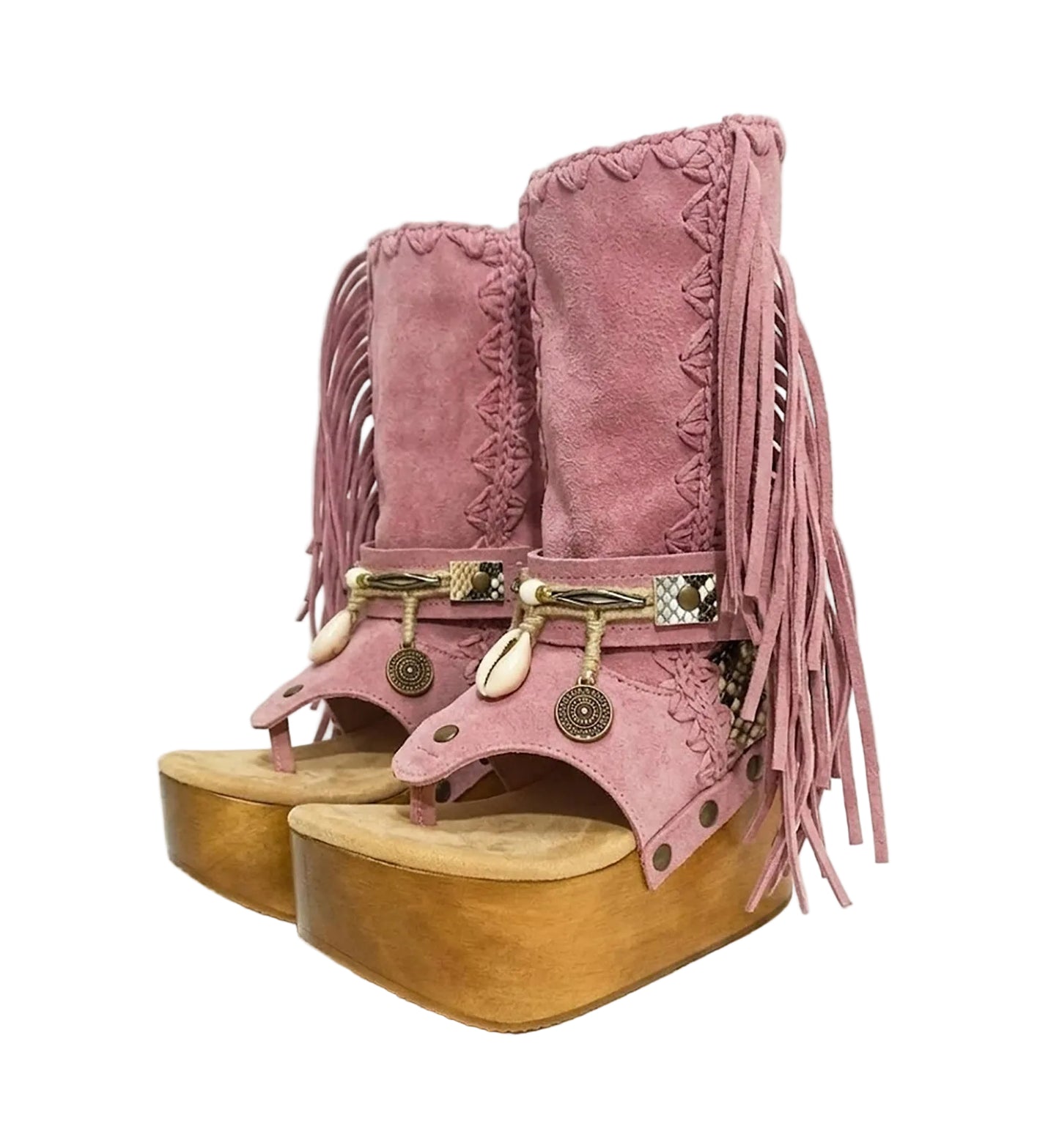 Handmade Atenea Pink Flip Flop Boots by Sol Caleyo, featuring pink suede leather, fringe details, shells, vintage coins, and a high wooden platform sole on a white background