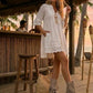 Model at a beach club wearing Atenea beige suede platform boots, showing the natural earthy tones and bohemian details in a sophisticated summer sunset setting