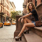 Model walking in New York City wearing the exotic Tokio Snake Clogs by Sol Caleyo, showcasing the python-print leather and high wenge platform against an urban brownstone backdrop.