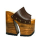 Side view of Sol Caleyo Brown Luxury Queen Sandals featuring deep brown leather, bronze studs, and a high architectural wooden platform heel against a white background.