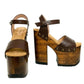 Side view of Sol Caleyo Crazy Brown Sandals featuring deep brown leather straps, ankle closure, and a 17 cm hand-carved wooden platform heel with bronze studs.