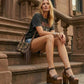 Model wearing the Crazy Brown Sandals by Sol Caleyo, highlighting the secure ankle strap and the dramatic height of the dark wood platform for a bold, artisanal look.