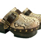 Handmade snake print leather clogs with brown leather strap and antique gold buckle on a wooden platform sole.