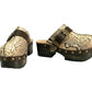 Handmade snake print leather clogs with brown leather strap and antique gold buckle on a wooden platform sole.