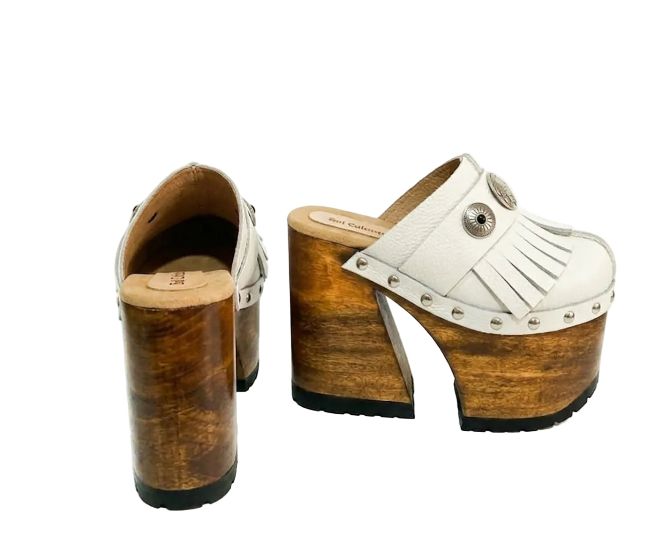 Side view of White Indian Clogs XL featuring extreme 17cm natural wood platform, white leather fringes, and antique silver metal conchos.