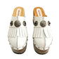 Side view of White Indian Clogs XL featuring extreme 17cm natural wood platform, white leather fringes, and antique silver metal conchos.