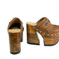 Side profile of Sol Caleyo Light Brown Indian Clogs XL featuring a high 17cm wooden platform, textured brown leather, decorative fringes, and antique metal conchos on a white background.