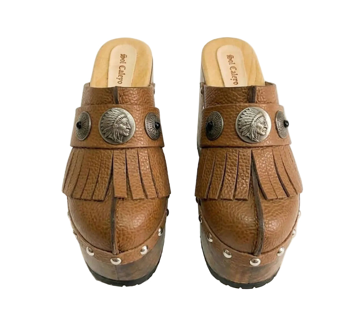Side profile of Sol Caleyo Light Brown Indian Clogs XL featuring a high 17cm wooden platform, textured brown leather, decorative fringes, and antique metal conchos on a white background.