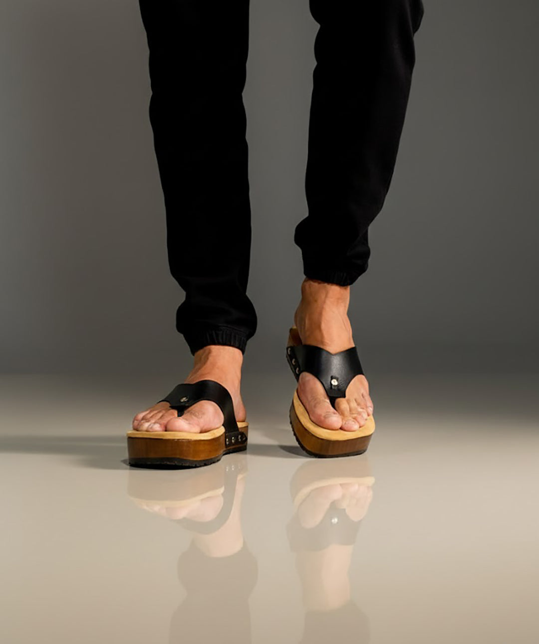 Men’s handmade black leather clogs with wooden sole, artisan flip-flop style sandals by Sol Caleyo.