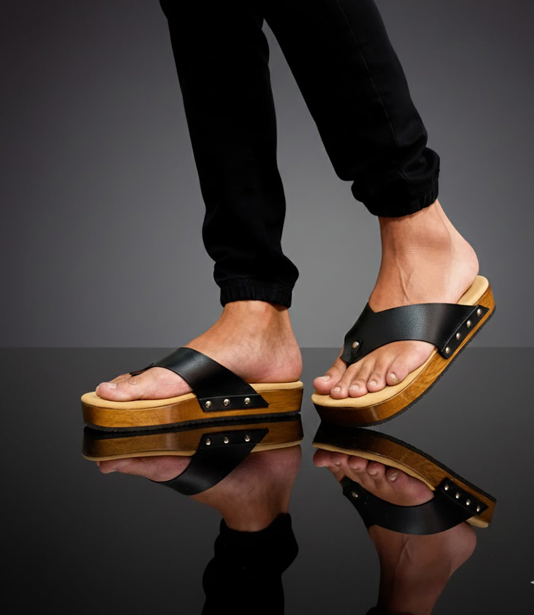 Black leather handcrafted men’s sandals with flat wooden sole and comfortable open clog design.
