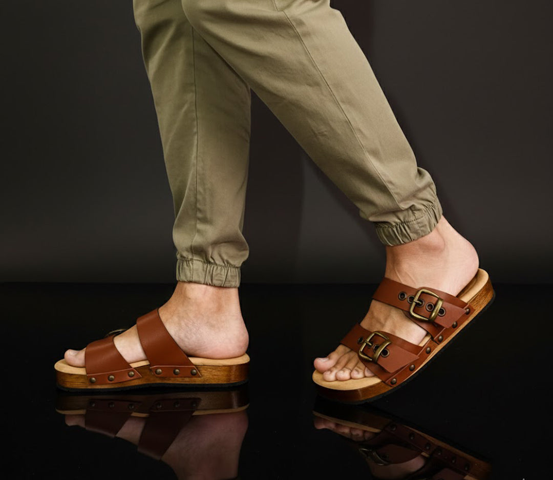 Man wearing handmade brown leather wooden sole sandals outdoors, showing fit and rugged style.