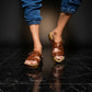 Man wearing handmade brown leather wooden sole sandals outdoors, showing fit and rugged style.