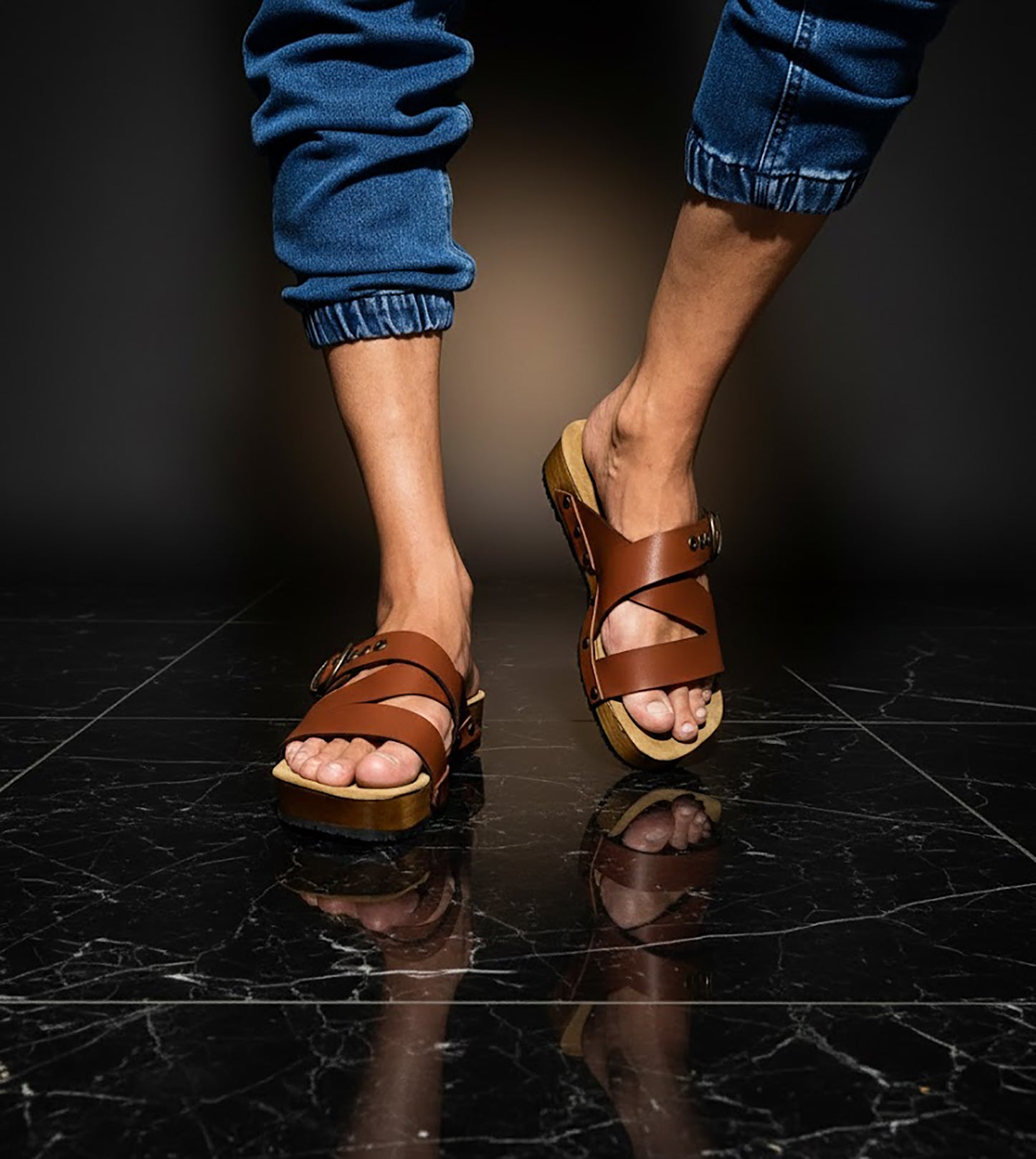 Man wearing handmade brown leather wooden sole sandals outdoors, showing fit and rugged style.