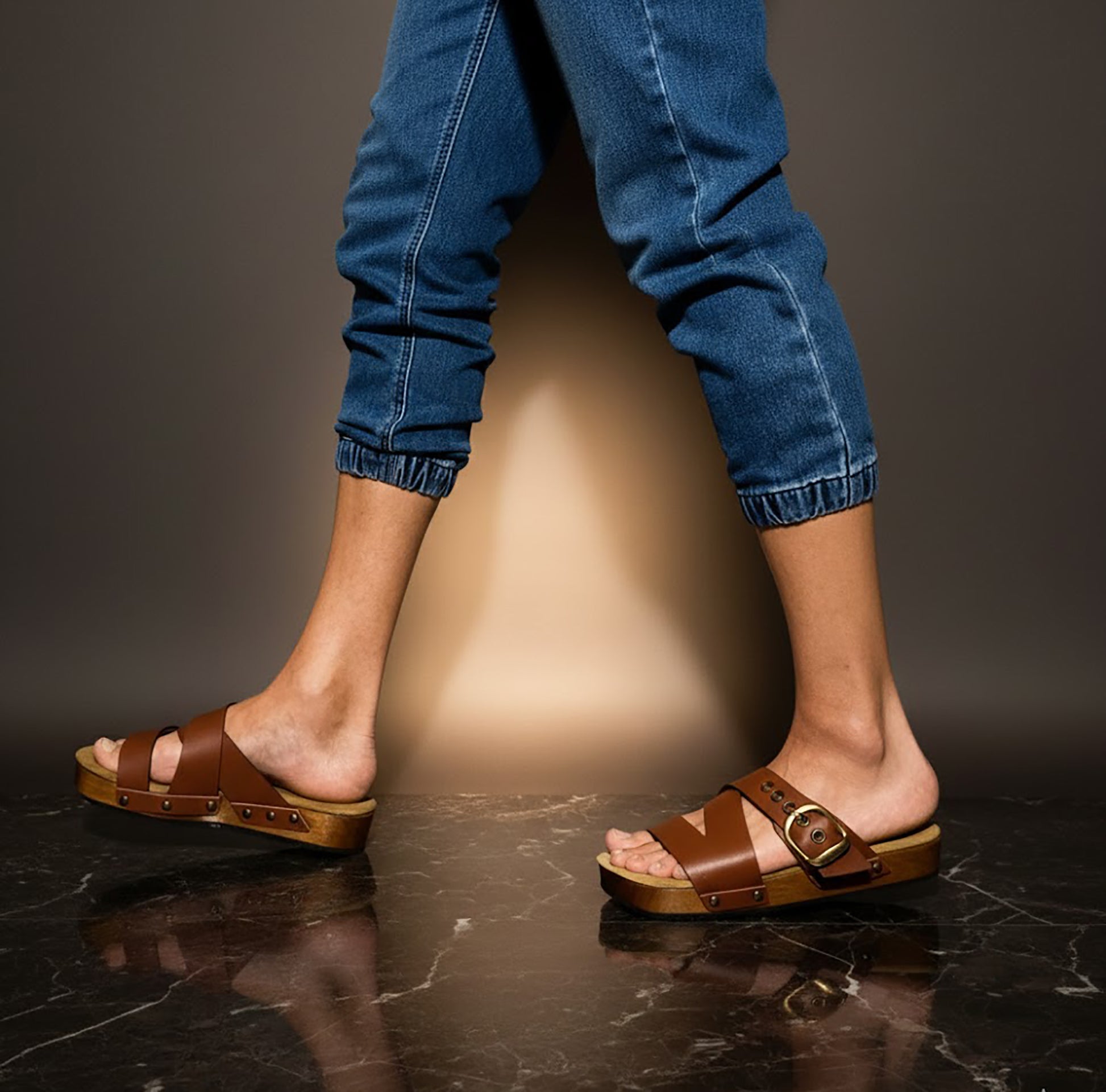 Man wearing handmade brown leather wooden sole sandals outdoors, showing fit and rugged style.