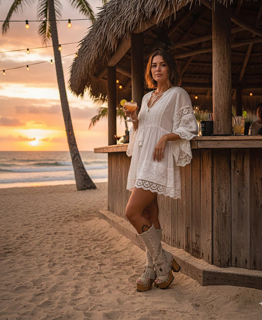 Handcrafted Dakota beige suede platform boots by Sol Caleyo featuring boho fringe, natural shells, and old gold coins on a 12cm sculpted wooden heel.