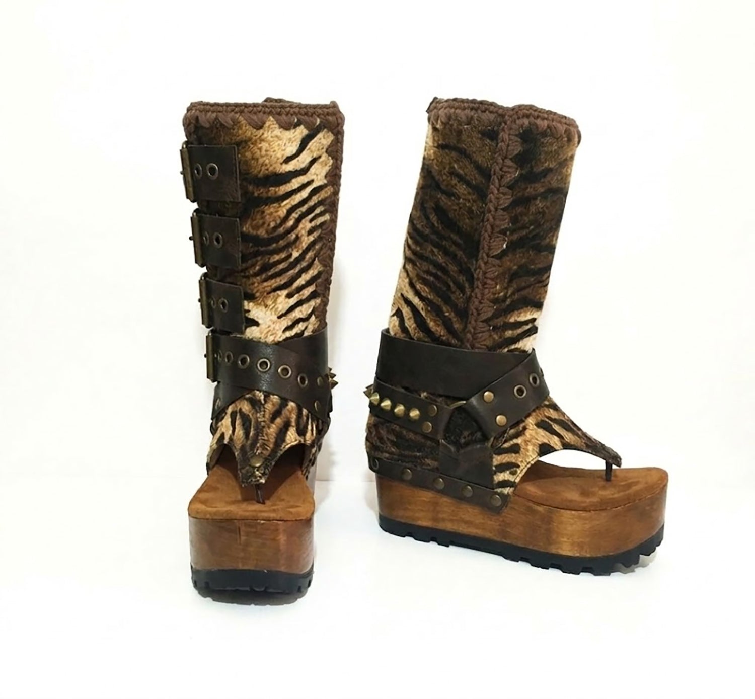 Close-up of Alabama Flip Flops Tiger Boots by Sol Caleyo. Features tiger-print premium leather, old gold pyramid studs, and a 10cm wooden wedge with black Vibram tractor soles.