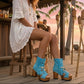 Bohemian style turquoise suede leather boots. Turquoise boots with wooden heel. Turquoise boots decorated with coins, horns and feathers, Boho Chic style. High-end handmade footwear by Sol Caleyo.