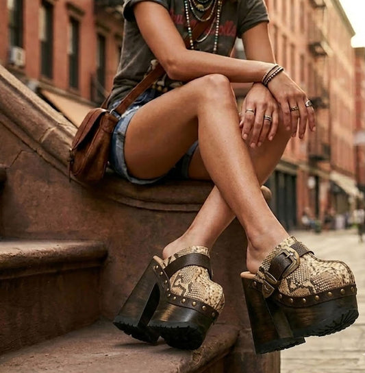 Fashion model showcasing the Route 66 XL snake print platform clogs with 17cm heels for an elongated, high-fashion silhouette.