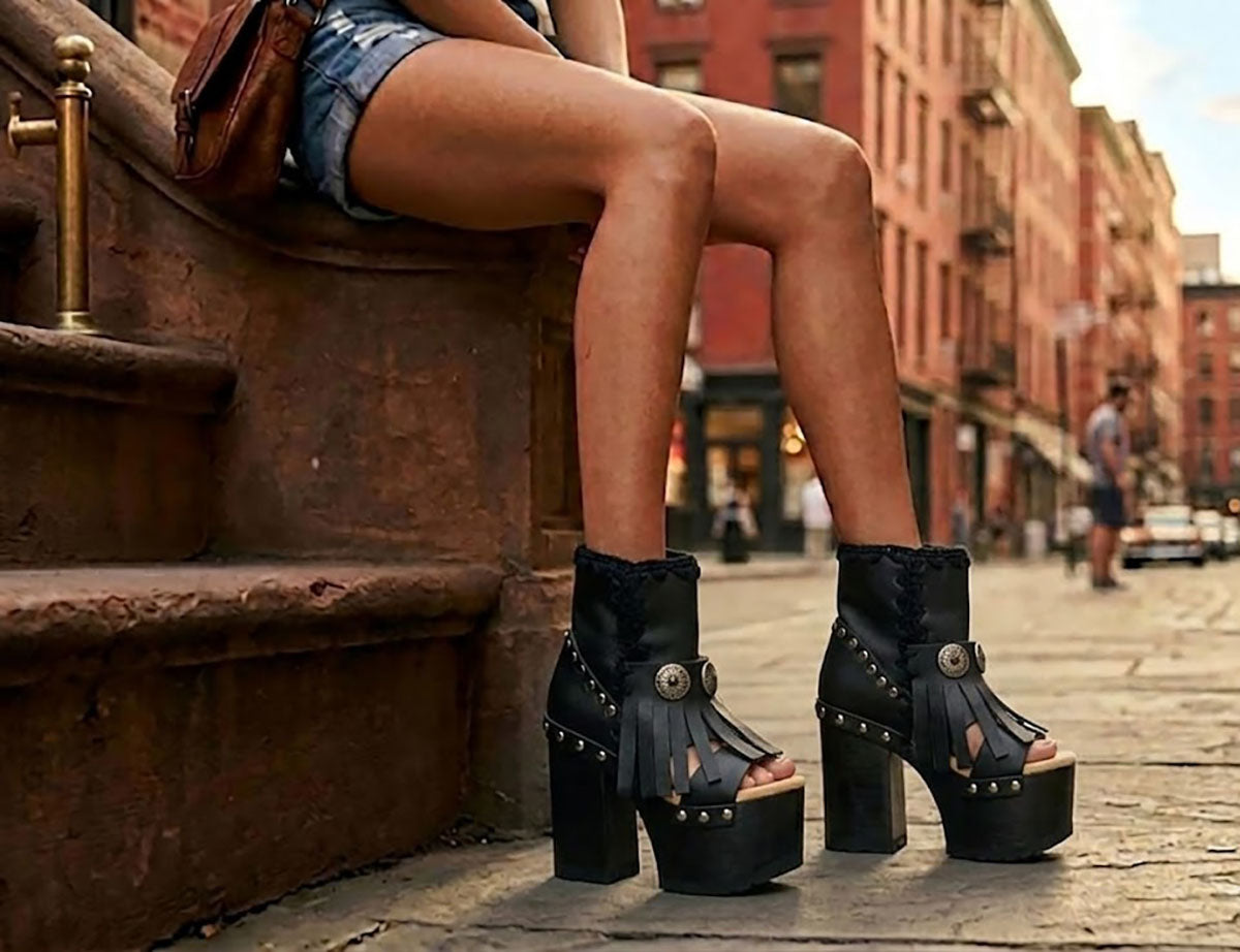 Model wearing Sol Caleyo bohemian leather platform sandals with wooden heel and silver decorative studs. High-end boho-chic summer outfit featuring artisan handcrafted footwear.
