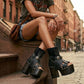 Model wearing Sol Caleyo bohemian leather platform sandals with wooden heel and silver decorative studs. High-end boho-chic summer outfit featuring artisan handcrafted footwear.