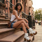 Model wearing Sol Caleyo bohemian leather platform sandals with wooden heel and silver decorative studs. High-end boho-chic summer outfit featuring artisan handcrafted footwear.