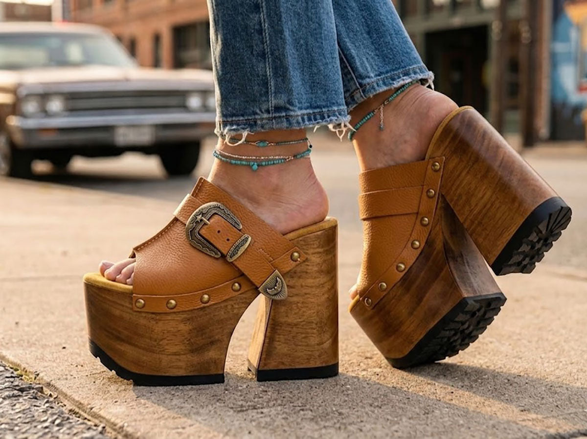 Sol Caleyo handmade Western platform clogs in premium camel leather with 17cm wooden heel and antique-brass concho buckle details.