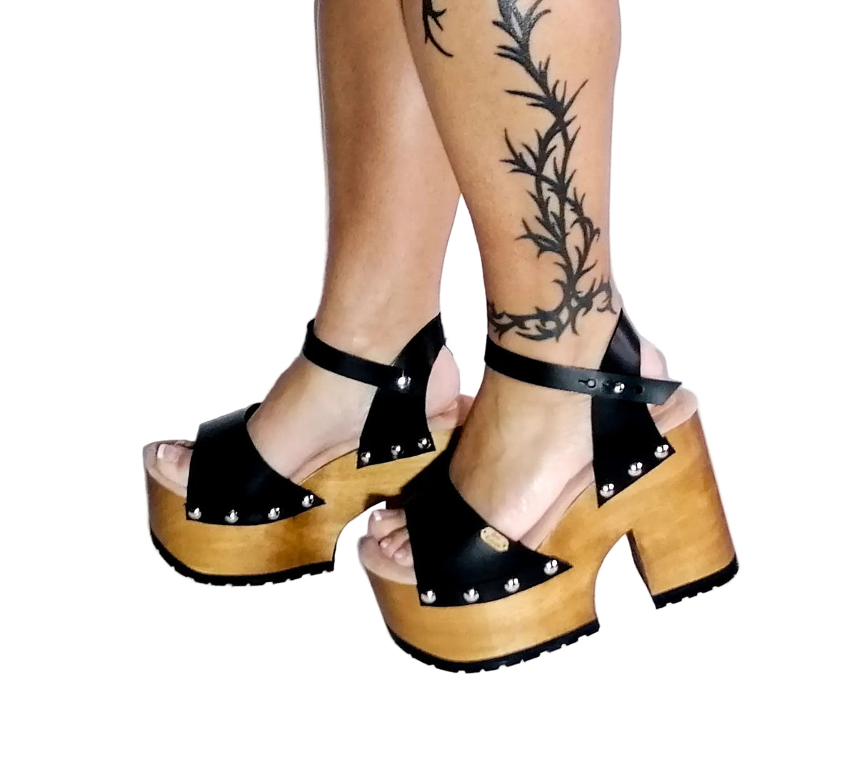 Handmade smooth black leather open toe platform sandals with wide ankle strap, round flat silver studs and 12 cm light natural lacquered wooden heel by Sol Caleyo.