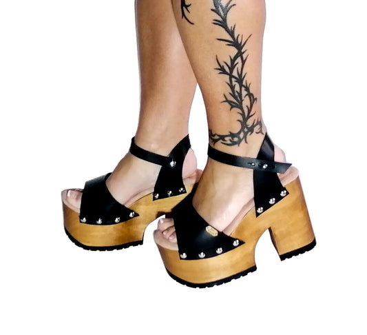 Handmade smooth black leather open toe platform sandals with wide ankle strap, round flat silver studs and 12 cm light natural lacquered wooden heel by Sol Caleyo.