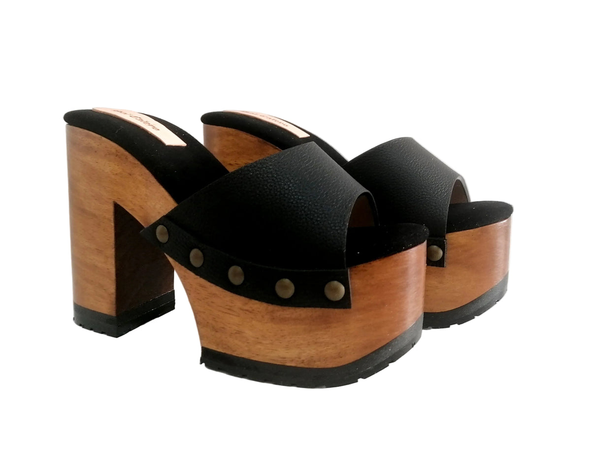 Handmade black leather peep toe platform mule sandals with old-gold studs and 12 cm natural lacquered wooden heel by Sol Caleyo.