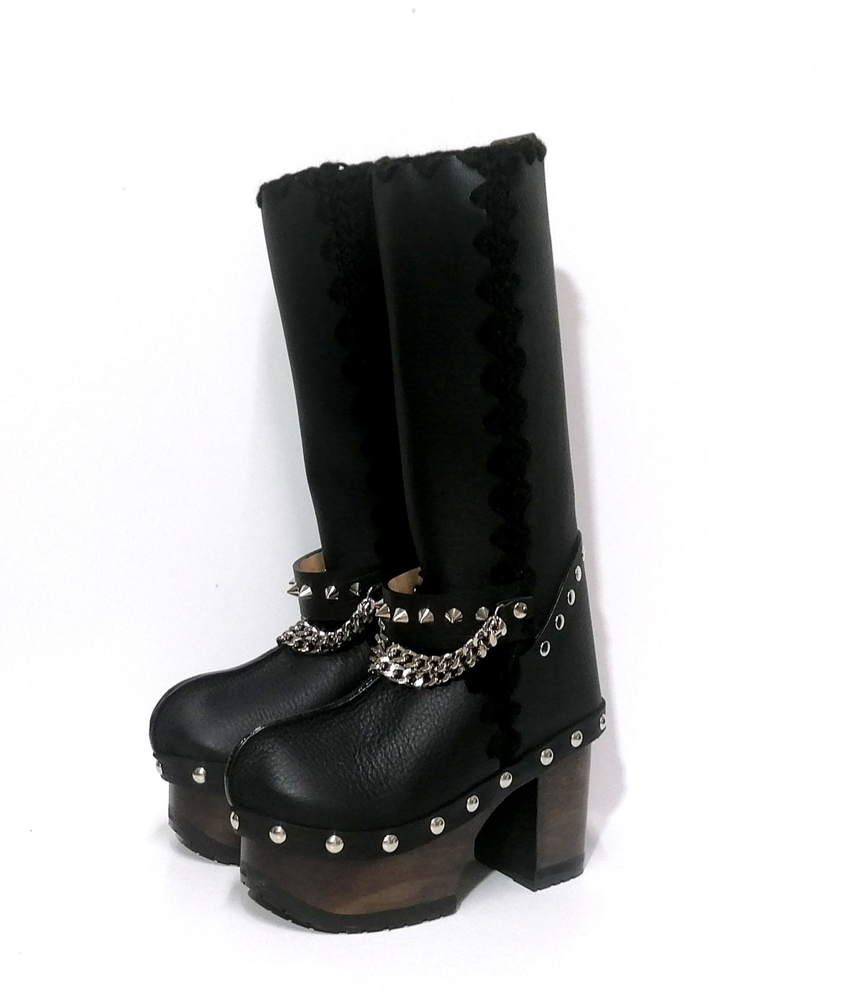 Handmade smooth black leather tall platform boots with silver pyramid studs on the heel, front chains and 10 cm wenge lacquered wooden heel by Sol Caleyo. 