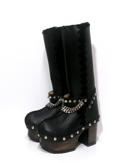 Handmade smooth black leather tall platform boots with silver pyramid studs on the heel, front chains and 10 cm wenge lacquered wooden heel by Sol Caleyo. 
