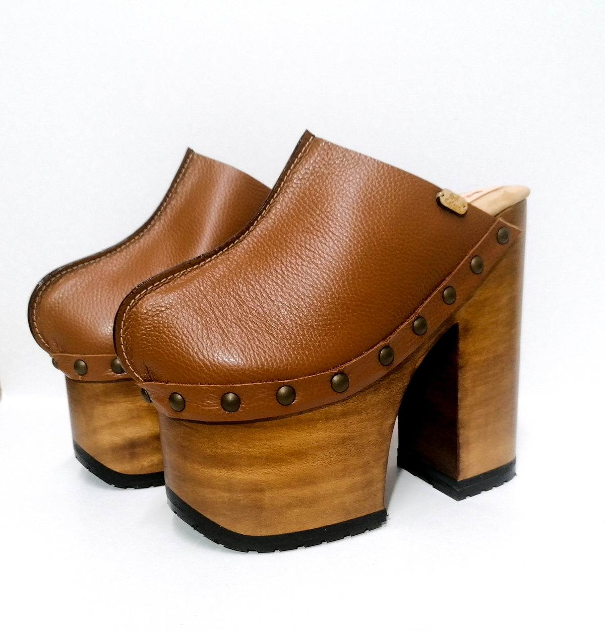 Handmade full-grain camel leather platform mule clogs with round flat old-gold studs and 17 cm natural lacquered wooden heel by Sol Caleyo.