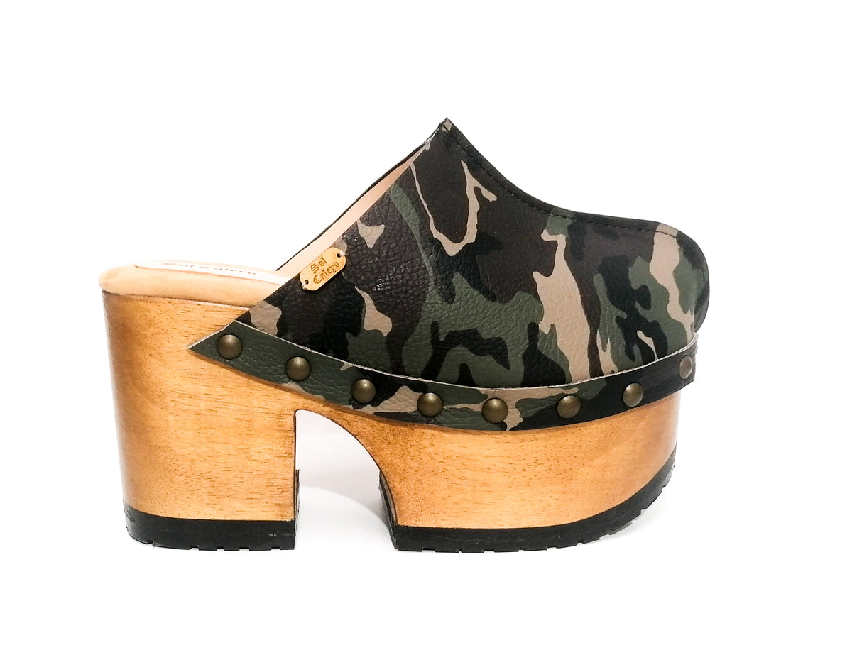 Handmade military green and brown camo print leather closed-toe platform mule clogs with round flat bronze studs and 10 cm natural lacquered wooden heel by Sol Caleyo.