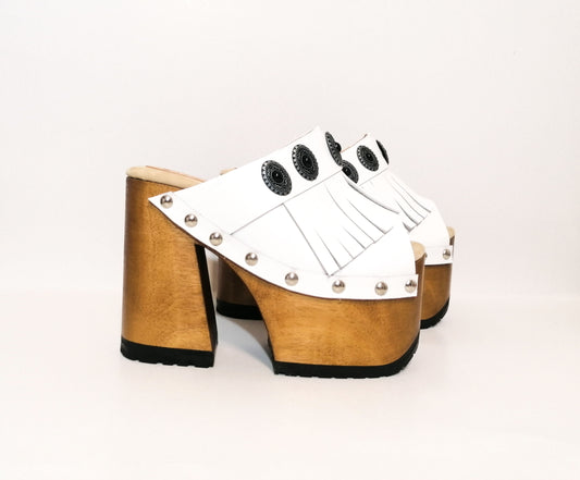 White leather sandal. White leather sandal boho style. White leather sandal decorated with fringes and silver conchos with a unique boho style. Wooden clog sandals with super high heels 70's style. Sizes 34 to 47. High quality handmade leather shoes by sol Caleyo. Sustainable fashion.