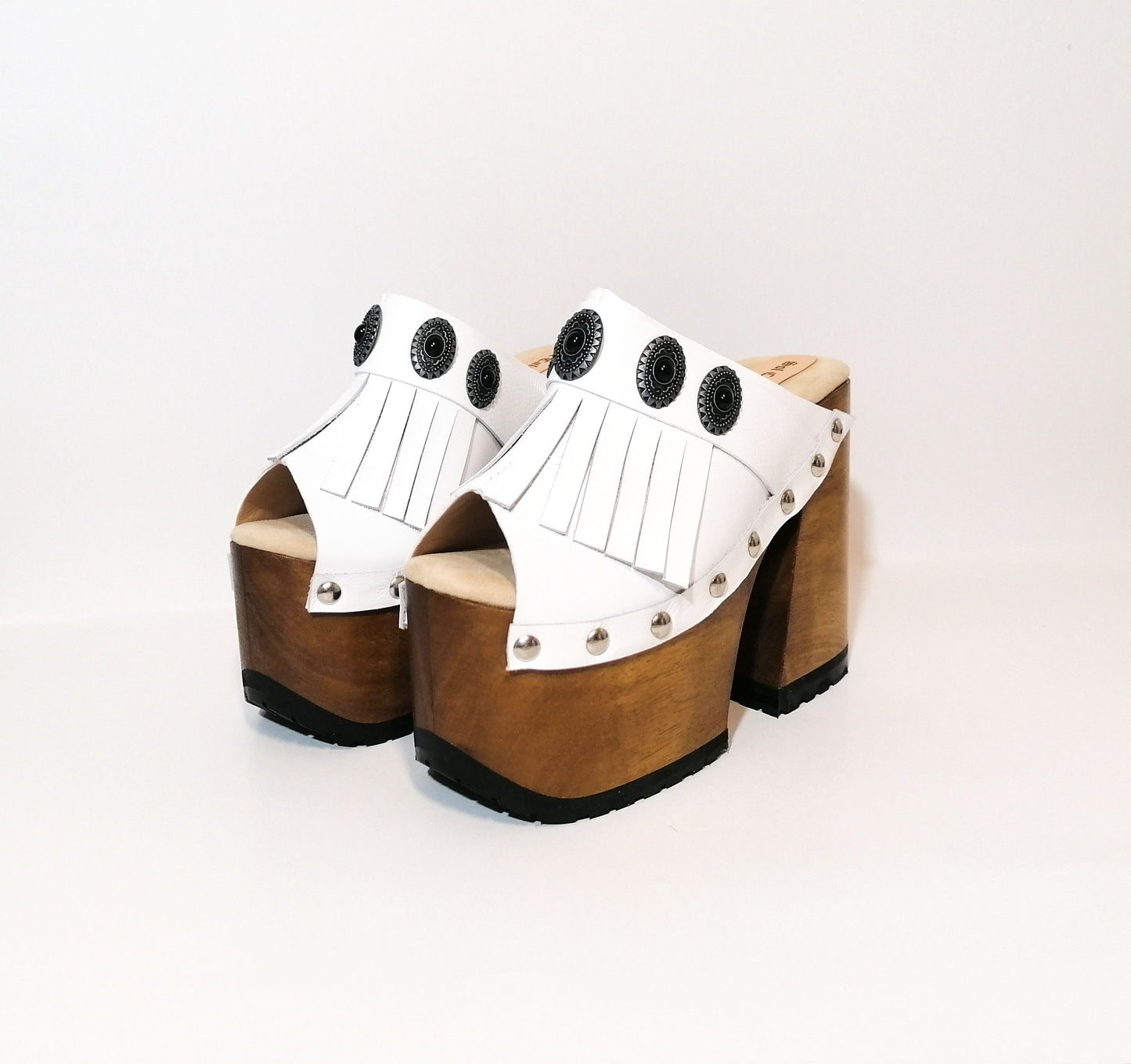 White leather sandal. White leather sandal boho style. White leather sandal decorated with fringes and silver conchos with a unique boho style. Wooden clog sandals with super high heels 70's style. Sizes 34 to 47. High quality handmade leather shoes by sol Caleyo. Sustainable fashion.