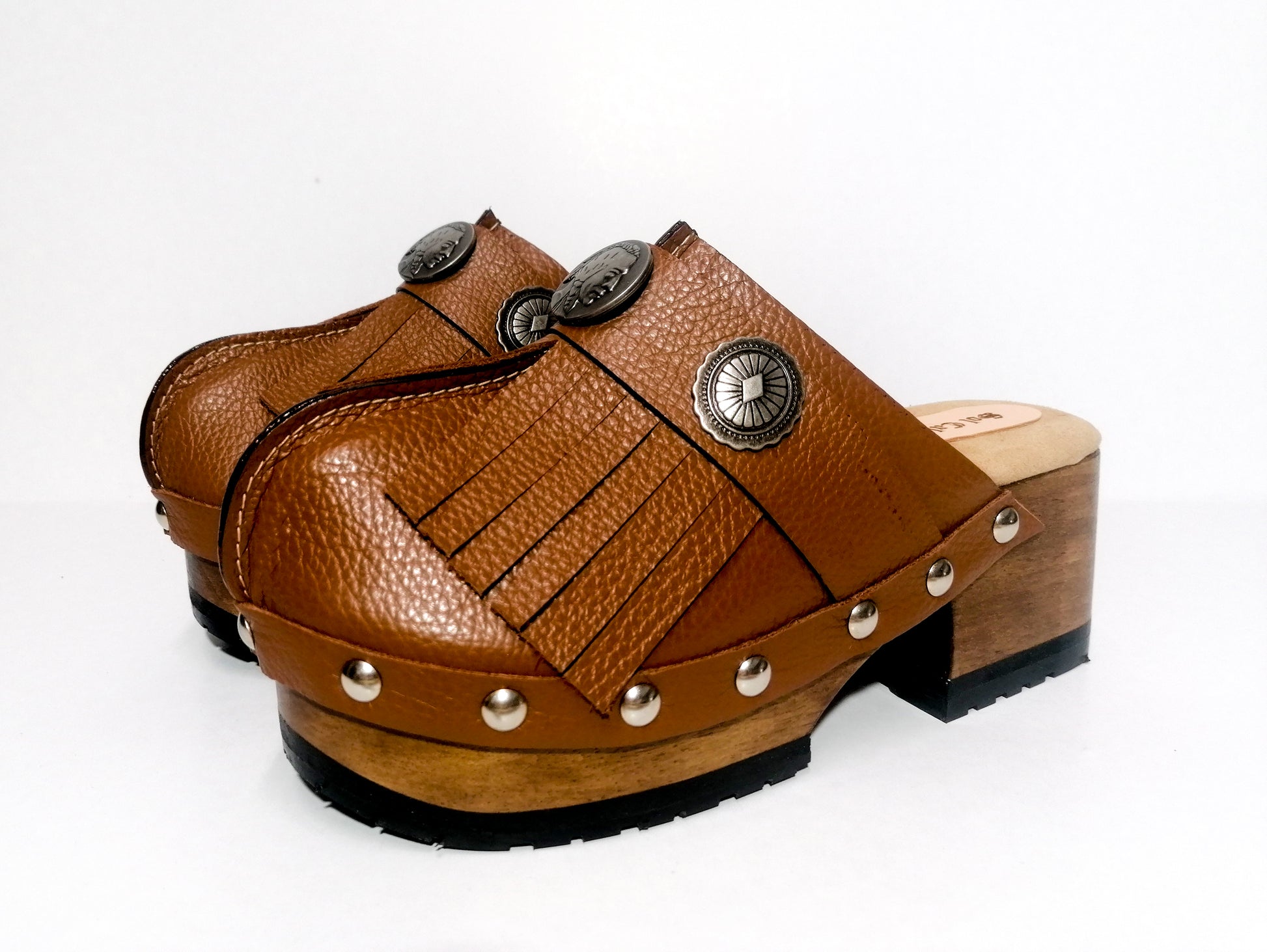 Brown platform clog vintage style 70s. Brown leather clog decorated with American Indian conchos. Leather clogs with wooden heel. Sizes 34 to 47. High quality leather shoes handmade by Sol Caleyo.