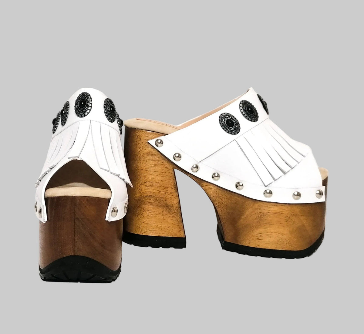 Fringe and silver conchos on handmade white boho sandals by Sol Caleyo