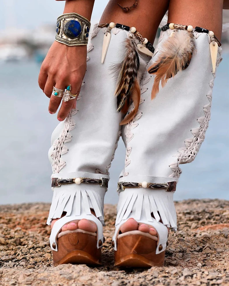Handmade white split suede open toe slouch wedge boots with fringe, natural feathers, horns, brown resin figure and python print heel on a 6 cm natural lacquered wooden wedge by Sol Caleyo.